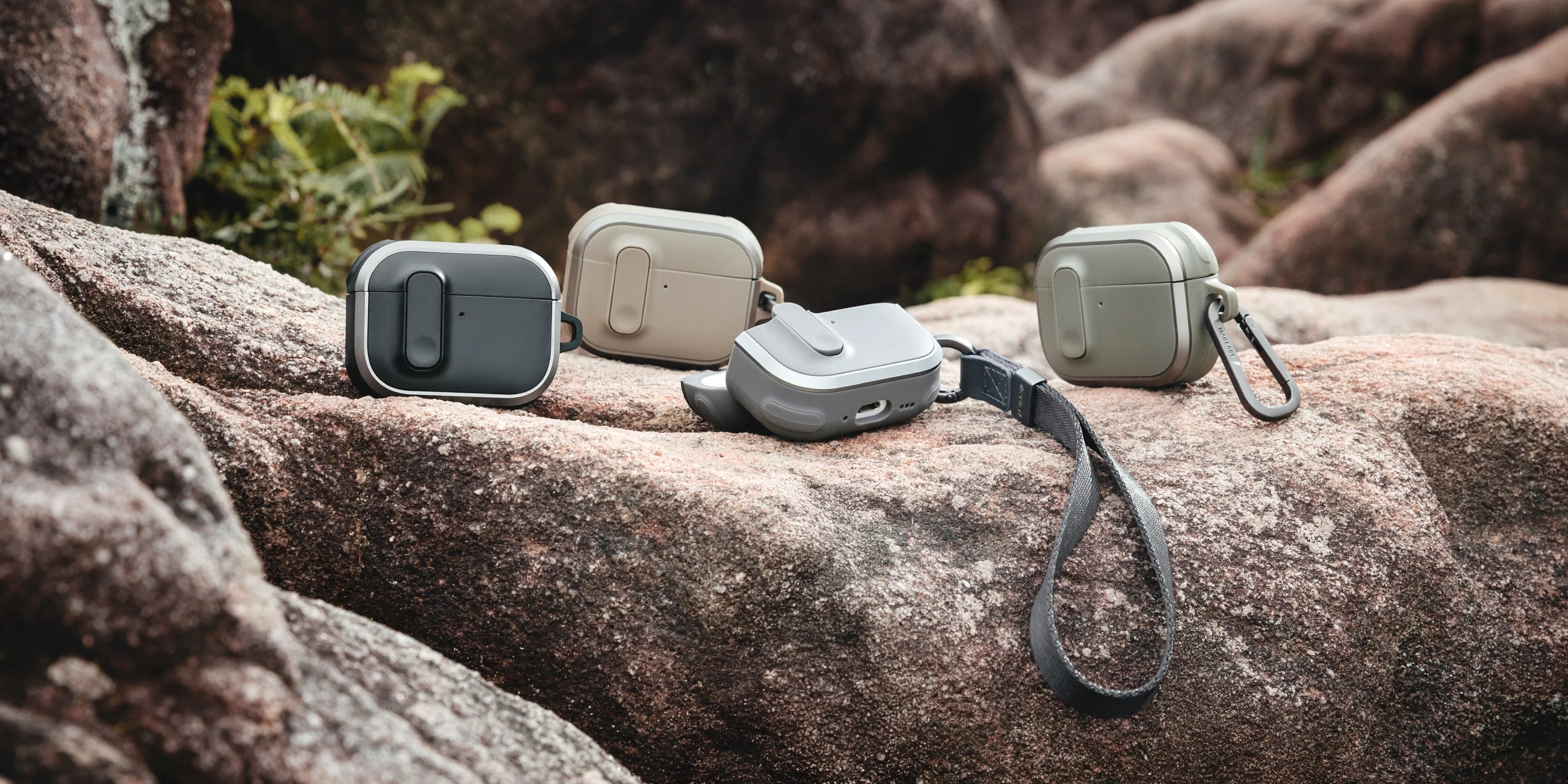 MAGEASY Odyssey AirPods Pro 3 case color lineup with strap and carabiner on rock surface